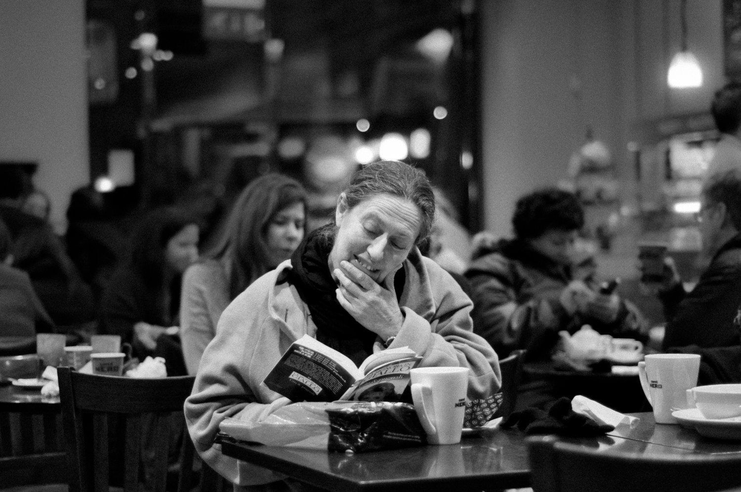 A woman reads a book in a coffee shop
