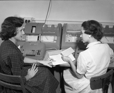 two ladies review an IBM keypunch card