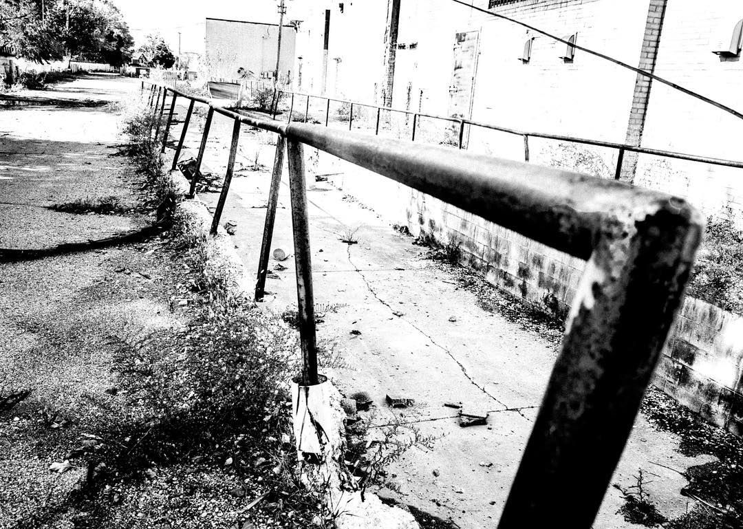 A dilapitated handrail in a decaying shopping mall