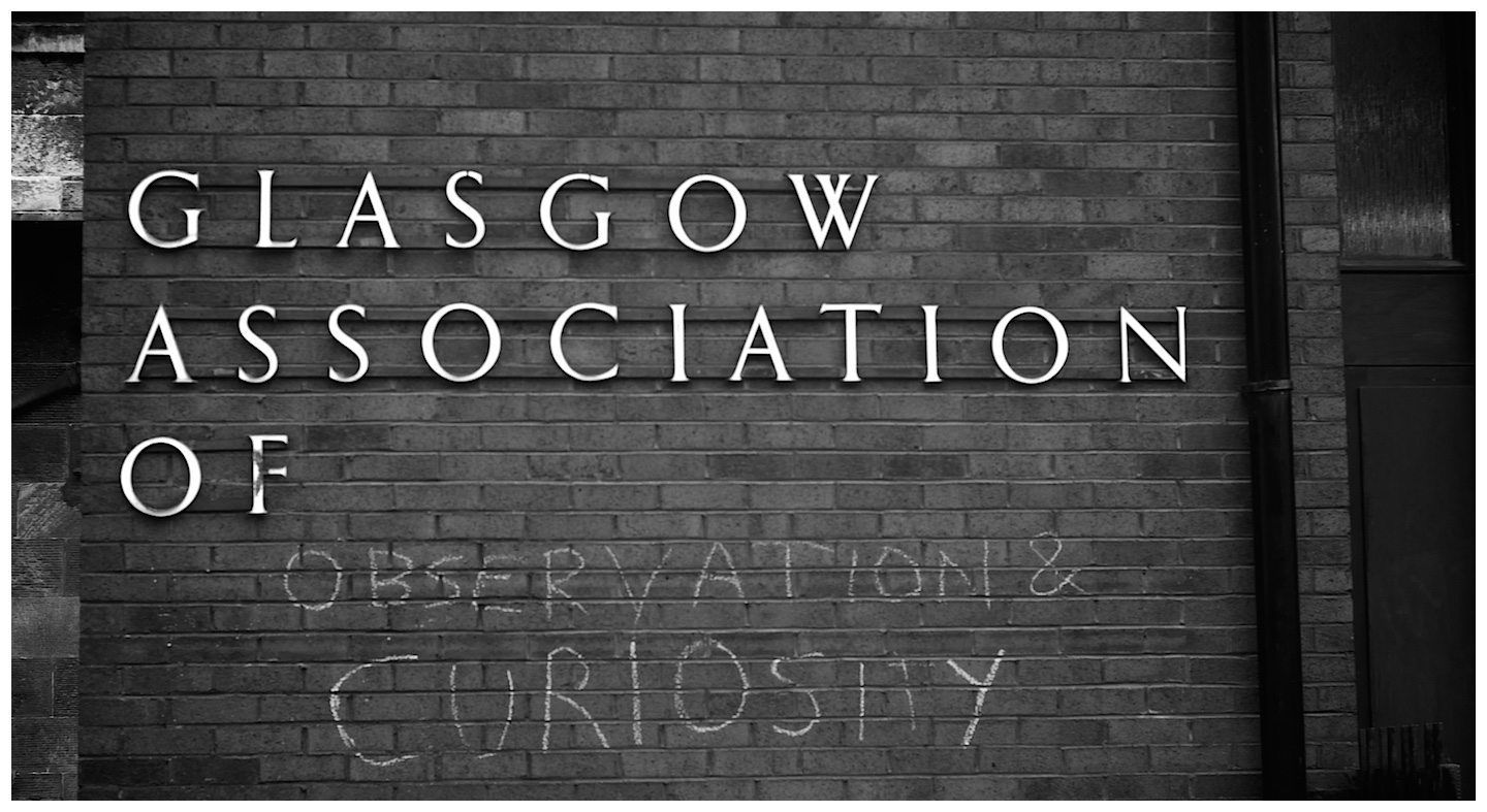 A building where Observation and Curiosity are written in chalk beneath the industrial name of the building, Glasgow Association