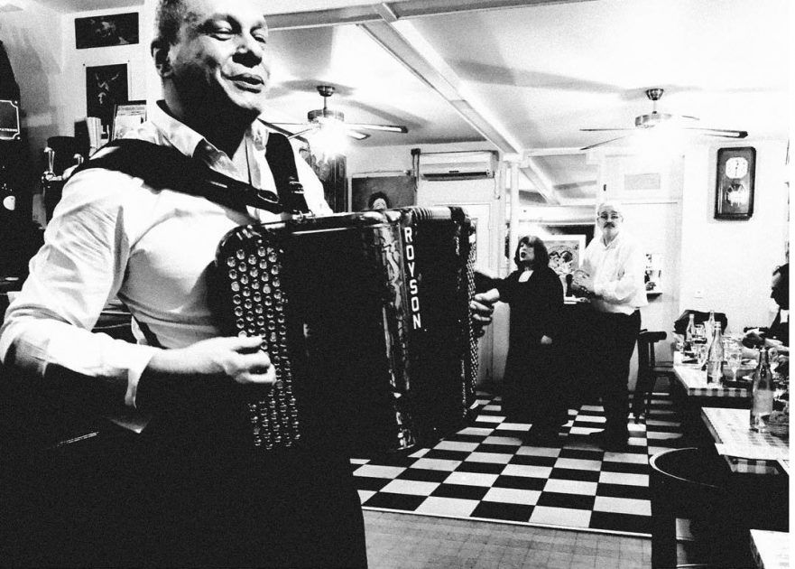 A man plays an accordion in a traditional Bistro. Shot with an iPhone 6 by Jay Sennett