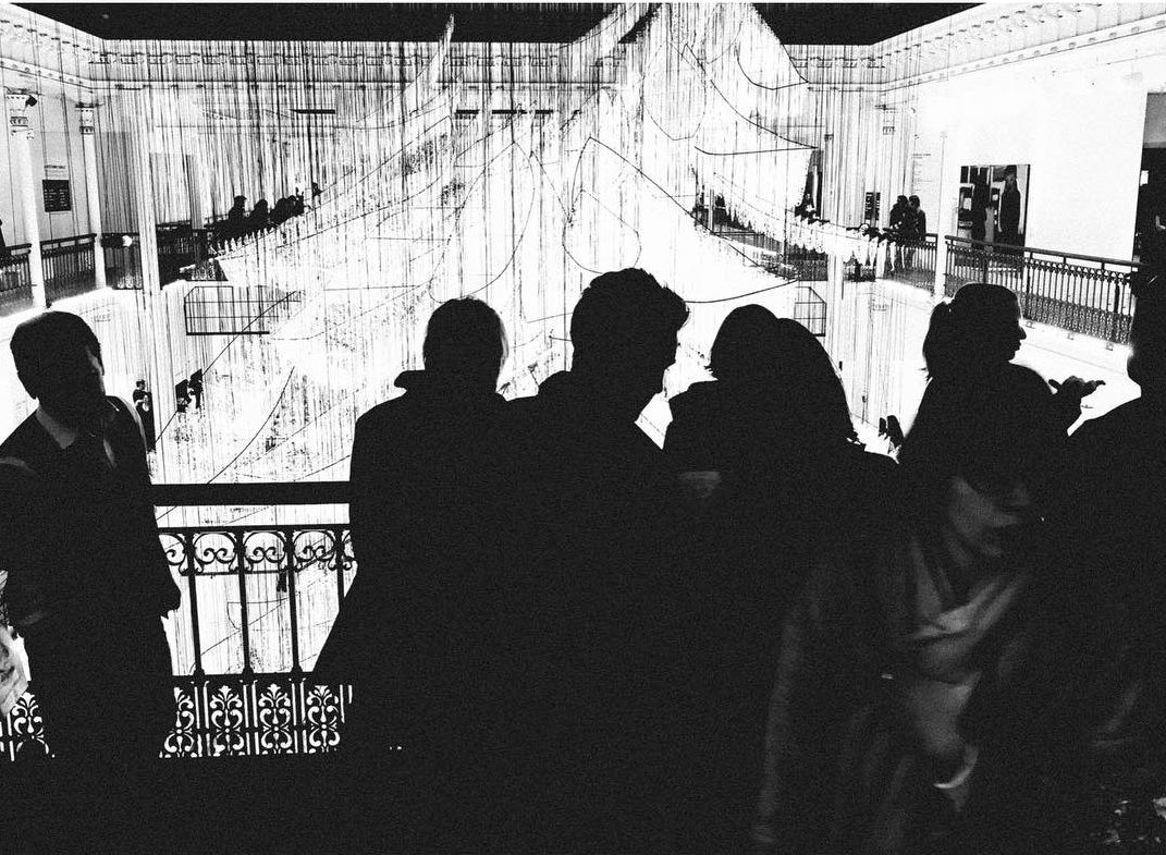 People standing in front of an escalator at Gallerie Lafayette. Shot with an iPhone 6 by Jay Sennett